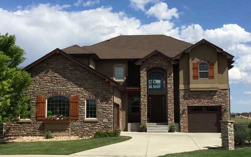 Remodeled home exterior with stone and stucco siding, new windows and doors and new roof by Mountain View Corporation in Colorado