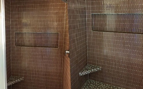 Stone arch doorway with iron gate for custom built wine cellar by Mountain View Corporation in Glendale Colorado