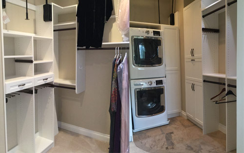 Walk in closet remodel with custom white cabinet for easy clothing and shoe storage, built in washer and dryer makes this the ultimate closet by Mountain View Corporation in Morrison Colorado