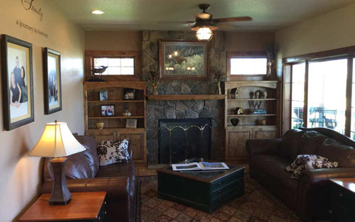 Remodeled living room with stone fireplace, hardwood floors, lighting fixtures and new paint by Mountain View Corporation in Broomfield Colorado