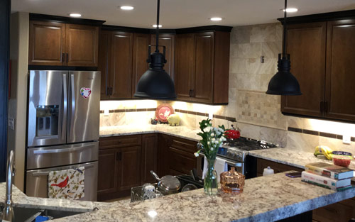 Stylish updated kitchen remodel with granite countertops, cherry wood custom cabinets and natural stone backsplash by Mountain View Corporation in Aurora Colorado