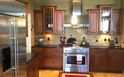 Modern kitchen remodel with cherry wood custom cabinets, stainless steel appliances and tile back splash by Mountain View Corporation in Colorado