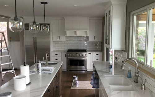 Modern home kitchen with quartz marble countertops, white wood cabinets, stainless steel appliances by Mountain View Corporation in Golden Colorado